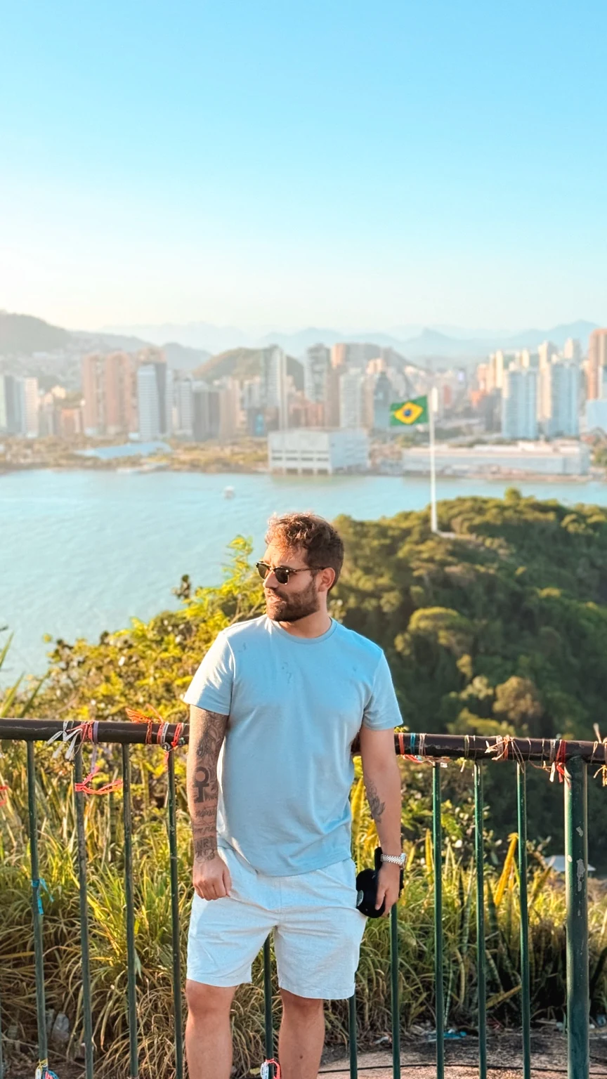 Rena em um mirante com cidade e mar ao fundo